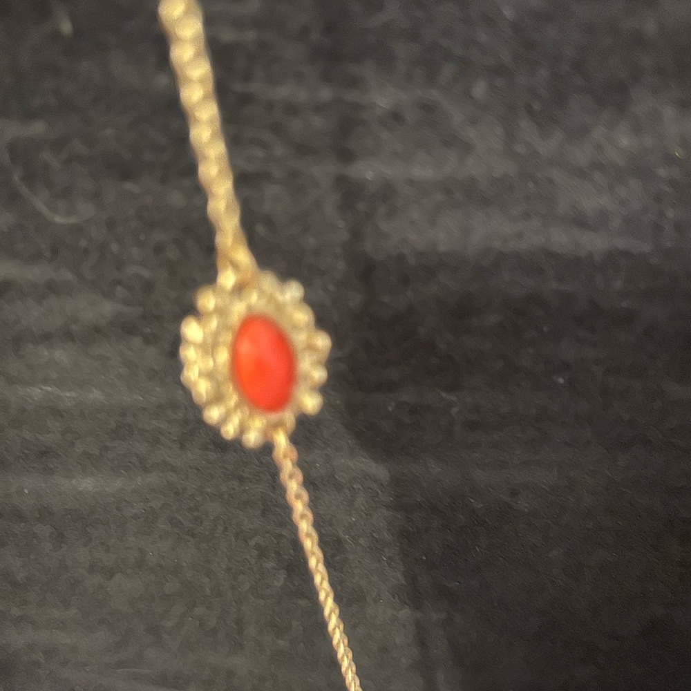 Orange colored beads on gold colored chain